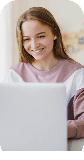 Student smiling at laptop